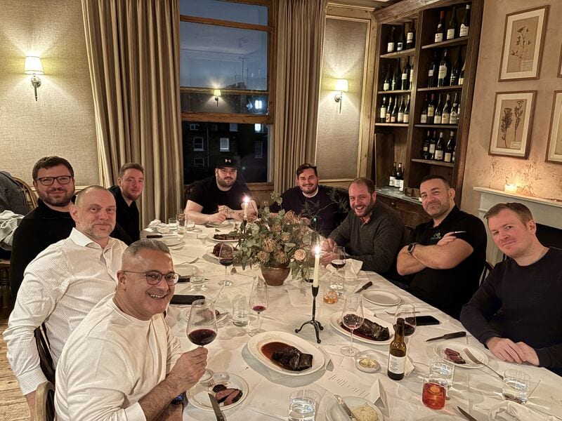 Nine of the Eido team around a dinner table.